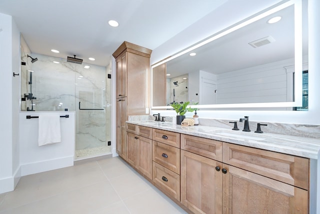 bathroom with a shower with door, vanity, and tile patterned flooring