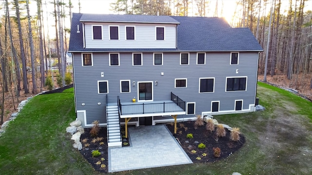 back of house featuring a wooden deck, a yard, and a patio