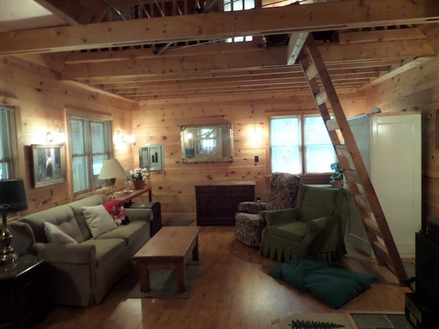 living room with beam ceiling, wood walls, and hardwood / wood-style floors