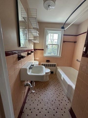283 Woodland Rd, Newton, MA 02466 - bathroom featuring toilet, tile walls, radiator heating unit, bathtub / shower combination, and a sink