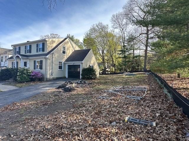 283 Woodland Rd, Newton, MA 02466 - view of side of home featuring an attached garage and aphalt driveway
