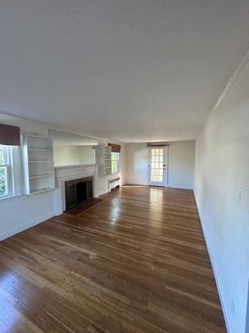 283 Woodland Rd, Newton, MA 02466 - unfurnished living room featuring baseboards, wood finished floors, and a fireplace