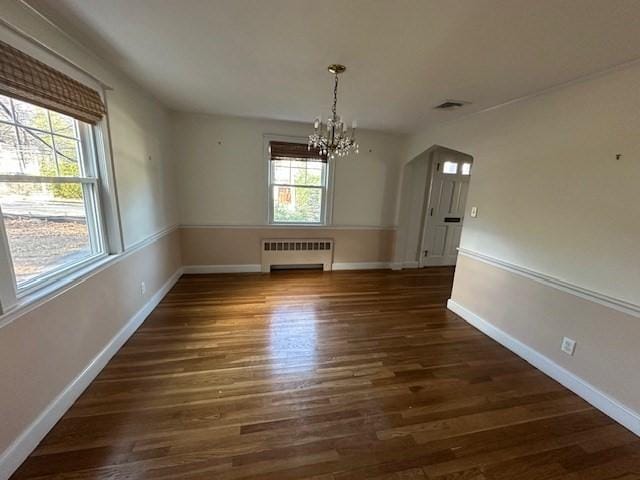 283 Woodland Rd, Newton, MA 02466 - unfurnished dining area featuring radiator, plenty of natural light, wood finished floors, and a notable chandelier