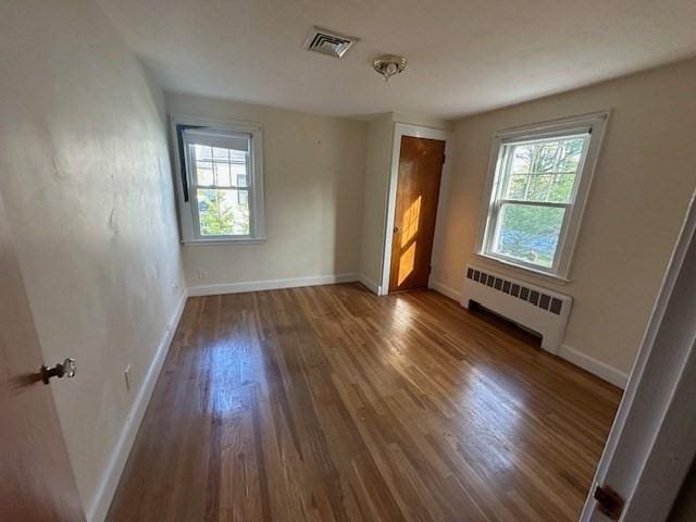 283 Woodland Rd, Newton, MA 02466 - unfurnished room with baseboards, radiator, wood finished floors, and visible vents