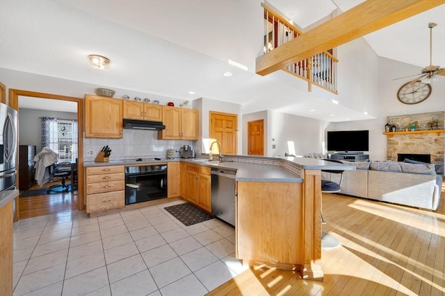 kitchen with dishwasher, sink, black oven, and kitchen peninsula