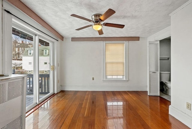 18 Newhall St, Malden, MA 02148 - unfurnished bedroom featuring access to exterior, multiple windows, a textured ceiling, and wood-type flooring