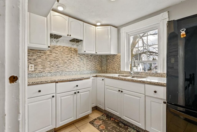 18 Newhall St, Malden, MA 02148 - kitchen featuring freestanding refrigerator, backsplash, white cabinets, light tile patterned floors, and light stone countertops