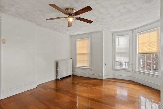 18 Newhall St, Malden, MA 02148 - spare room featuring radiator heating unit, wood finished floors, ceiling fan, and a textured ceiling