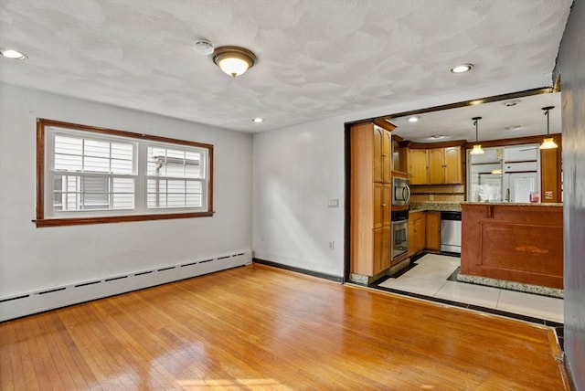 18 Newhall St, Malden, MA 02148 - kitchen with appliances with stainless steel finishes, brown cabinets, a baseboard heating unit, light wood-style floors, and recessed lighting