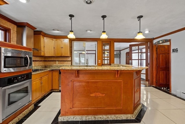 18 Newhall St, Malden, MA 02148 - kitchen featuring appliances with stainless steel finishes, light tile patterned flooring, crown molding, a center island, and light stone counters
