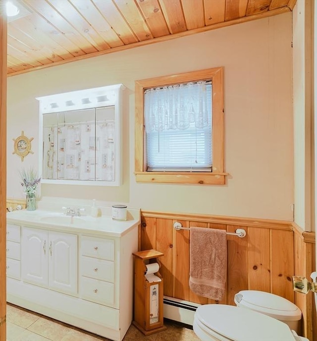 full bathroom with wood ceiling, a baseboard heating unit, toilet, vanity, and wainscoting