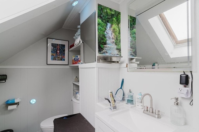 half bathroom with a skylight, a sink, lofted ceiling, and toilet