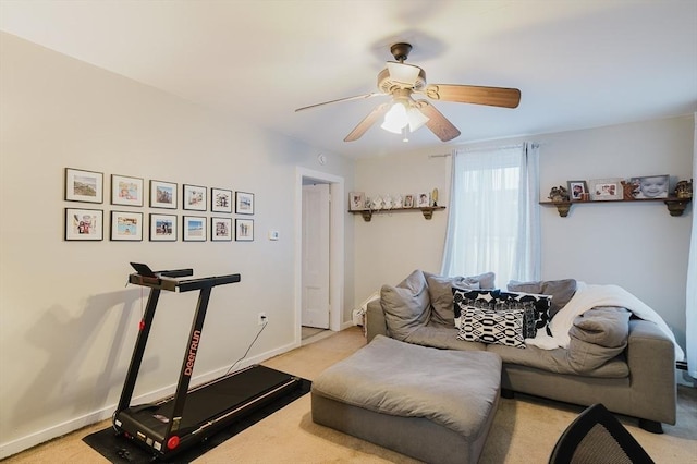workout room with a ceiling fan, baseboards, and light carpet
