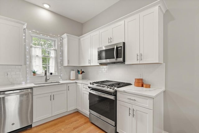25 Conant St Unit 1, Danvers, MA 01923 - kitchen with appliances with stainless steel finishes, a sink, white cabinetry, light stone counters, and recessed lighting