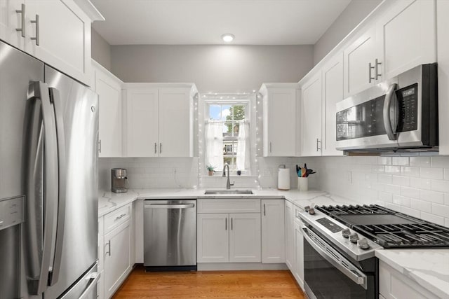 25 Conant St Unit 1, Danvers, MA 01923 - kitchen featuring stainless steel appliances, a sink, white cabinetry, and light wood-style floors