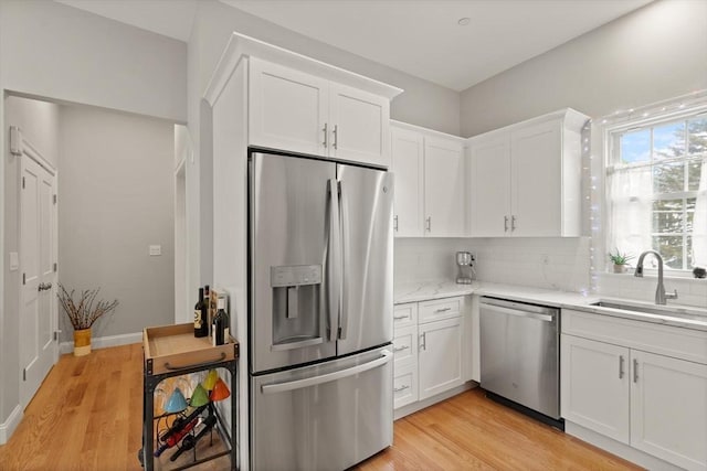 25 Conant St Unit 1, Danvers, MA 01923 - kitchen with appliances with stainless steel finishes, a sink, white cabinetry, and light wood-style flooring