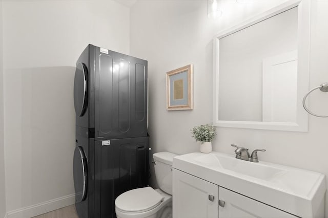 25 Conant St Unit 1, Danvers, MA 01923 - bathroom with stacked washer / dryer, toilet, vanity, and baseboards