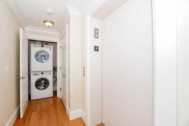 324 Front St Unit 4, Marion, MA 02738 - laundry room with stacked washer and clothes dryer, light wood-style floors, and crown molding