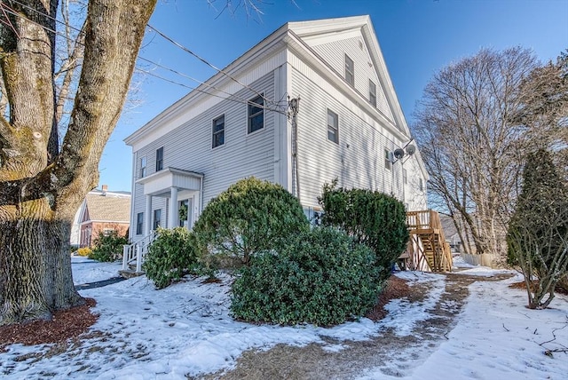 view of snow covered exterior featuring a wooden deck