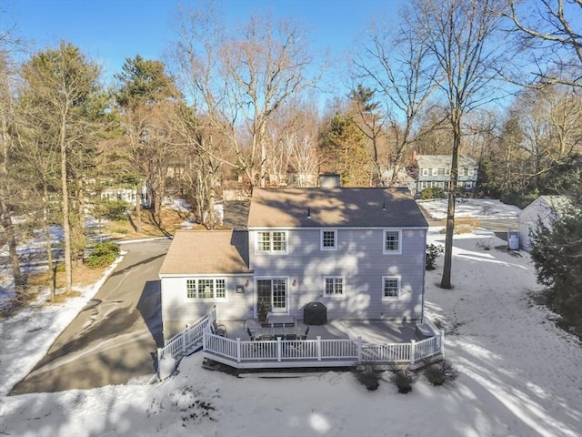 snow covered rear of property featuring a wooden deck