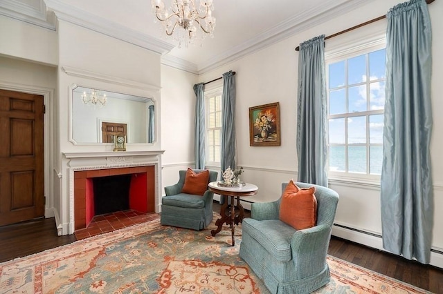 sitting room featuring ornamental molding, wood finished floors, a notable chandelier, and a tile fireplace