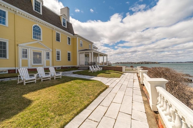 view of community featuring a yard and a water view
