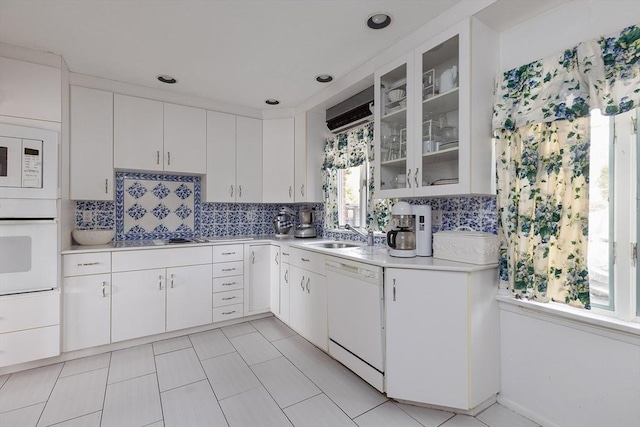 178 Rawson Rd, Brookline, MA 02445 - kitchen with glass insert cabinets, a sink, light countertops, white appliances, and backsplash