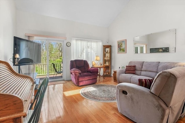 living room featuring high vaulted ceiling and light wood finished floors