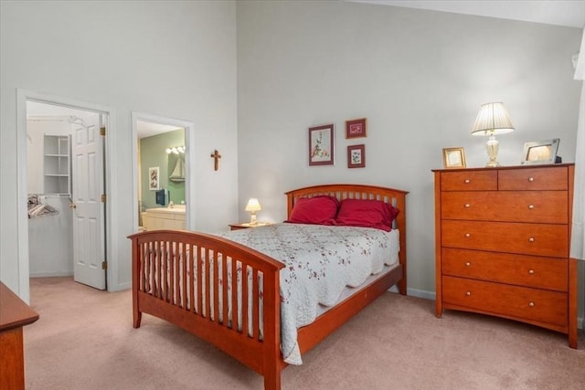 bedroom featuring a towering ceiling, ensuite bathroom, a closet, carpet, and a spacious closet