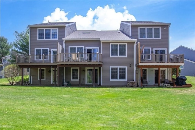 back of house featuring a lawn and a deck