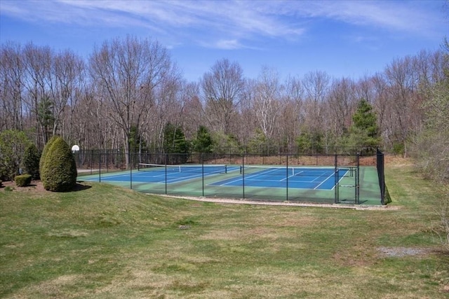 view of basketball court with a tennis court, fence, and a lawn