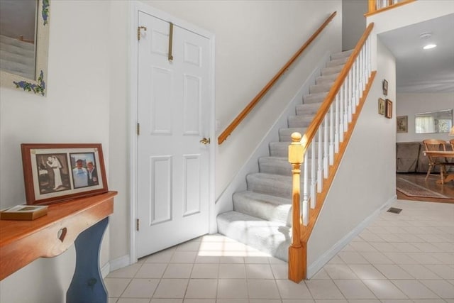 staircase with tile patterned floors, recessed lighting, and baseboards
