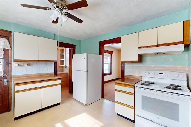 kitchen featuring white appliances, light floors, light countertops, under cabinet range hood, and white cabinetry