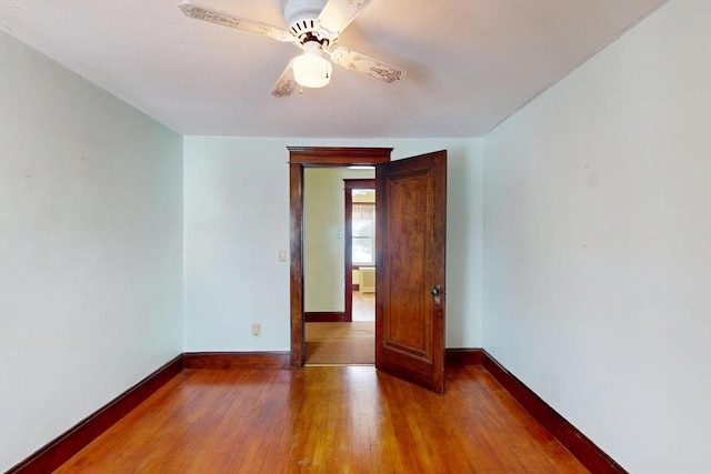 spare room with a ceiling fan, baseboards, and hardwood / wood-style flooring