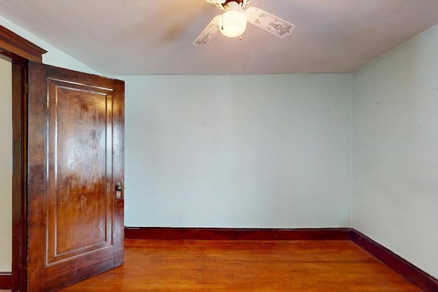 unfurnished room featuring wood finished floors, a ceiling fan, and baseboards