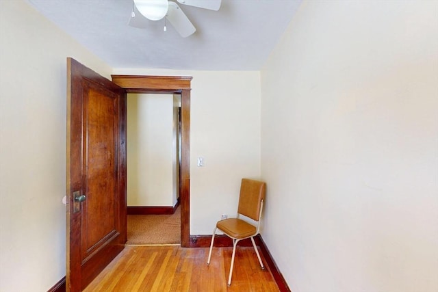 interior space featuring light wood finished floors, a ceiling fan, and baseboards