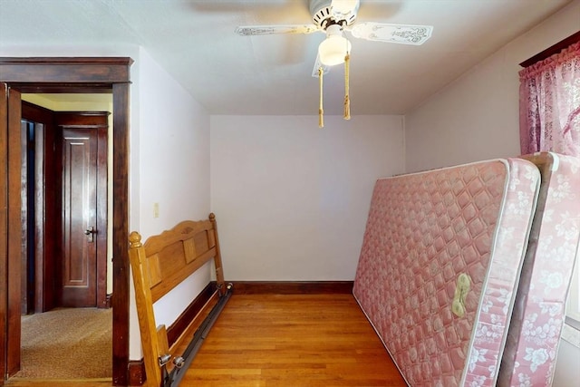 interior space featuring ceiling fan, light wood-style flooring, and baseboards