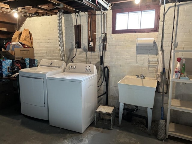 clothes washing area with laundry area, separate washer and dryer, and a sink