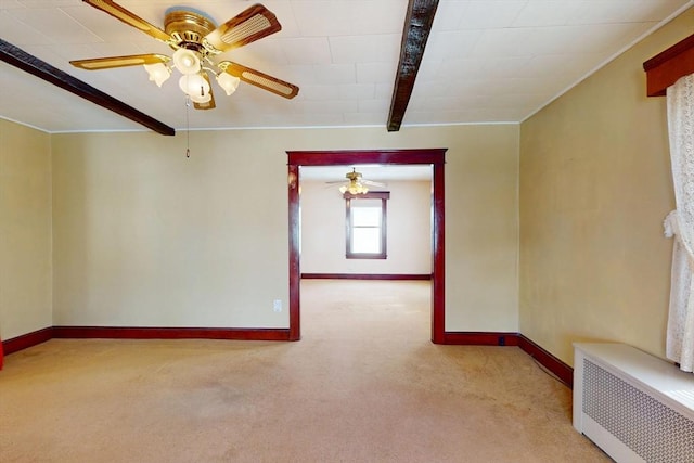 spare room featuring light carpet, radiator heating unit, baseboards, and beam ceiling