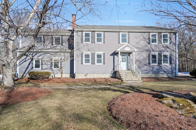 colonial house with a chimney and a front lawn