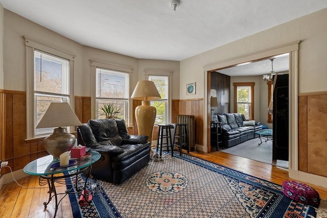 living area featuring a wainscoted wall, a healthy amount of sunlight, and hardwood / wood-style floors