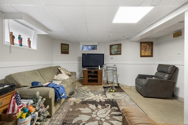 living room featuring baseboards, baseboard heating, and a drop ceiling