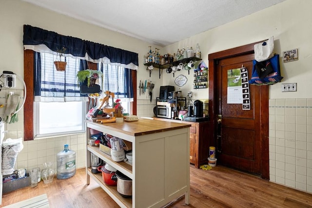 kitchen with butcher block countertops, open shelves, plenty of natural light, and tile walls