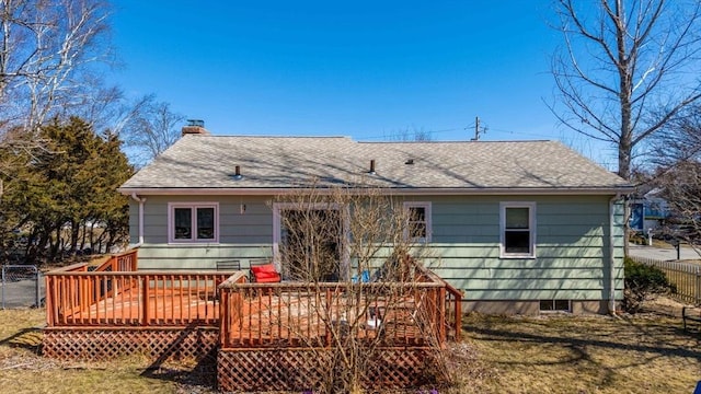 back of house with a deck, fence, roof with shingles, and a chimney