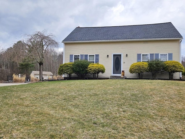 view of front facade with entry steps, roof with shingles, and a front lawn