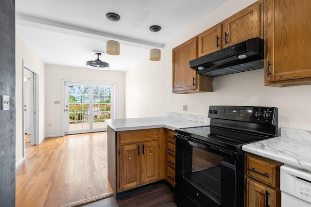 103 Claybourne Unit 103, Boston, MA 02124 - kitchen with black range with electric cooktop, under cabinet range hood, wood finished floors, brown cabinets, and a peninsula
