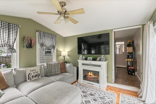 30 Taylor St Unit 1, Haverhill, MA 01832 - living room with ceiling fan, vaulted ceiling, light wood finished floors, baseboards, and a warm lit fireplace