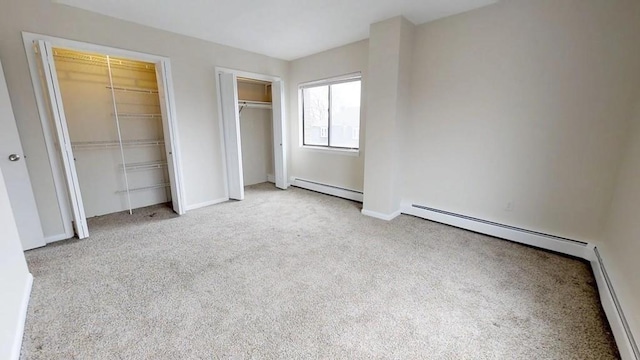 10 Williams Unit 39, Watertown, MA 02472 - unfurnished bedroom featuring two closets, baseboard heating, carpet flooring, and baseboards