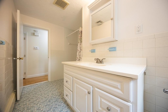 286 Mountain St, Sharon, MA 02067 - full bathroom with tile walls, vanity, tile patterned flooring, and a wainscoted wall