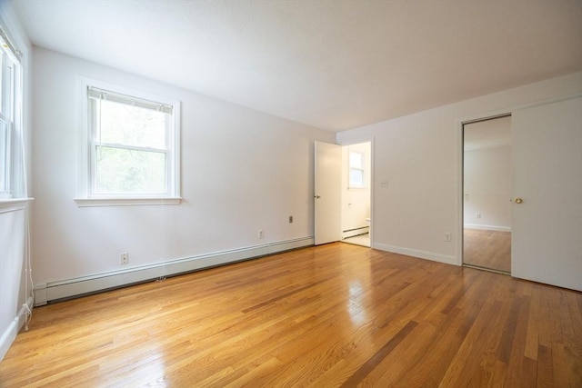 286 Mountain St, Sharon, MA 02067 - unfurnished bedroom featuring a baseboard heating unit, light wood finished floors, multiple windows, and baseboard heating